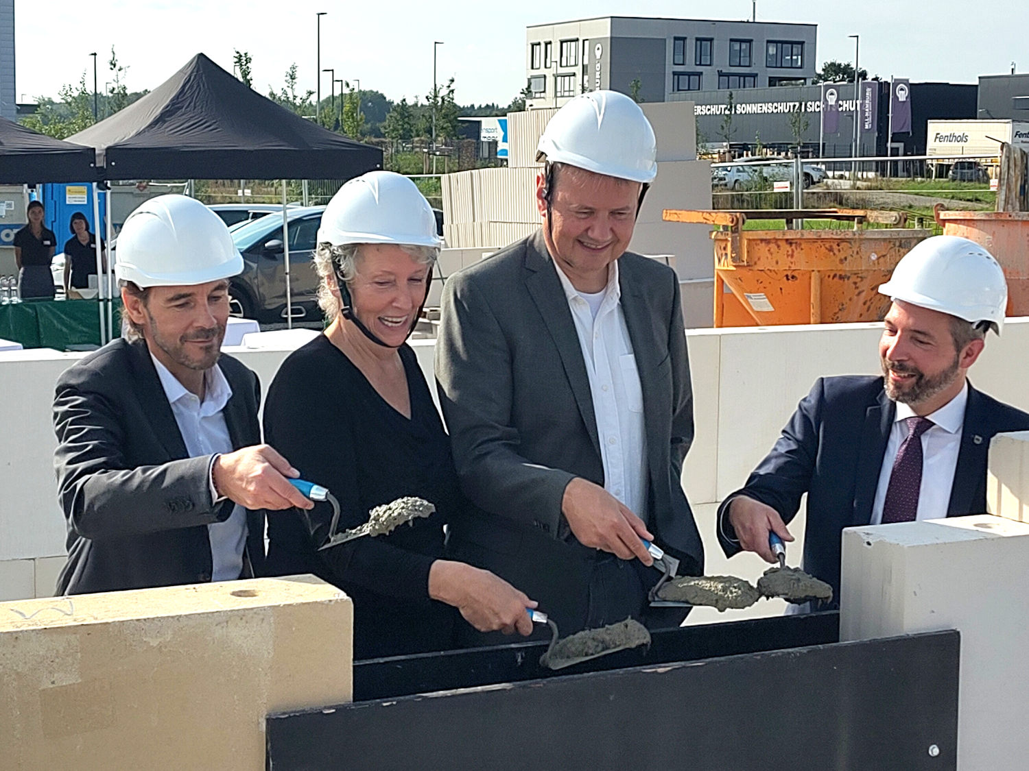 The management and the mayor of the city (right) walling in the time capsule (filled with photos, ads, documents, and a product)