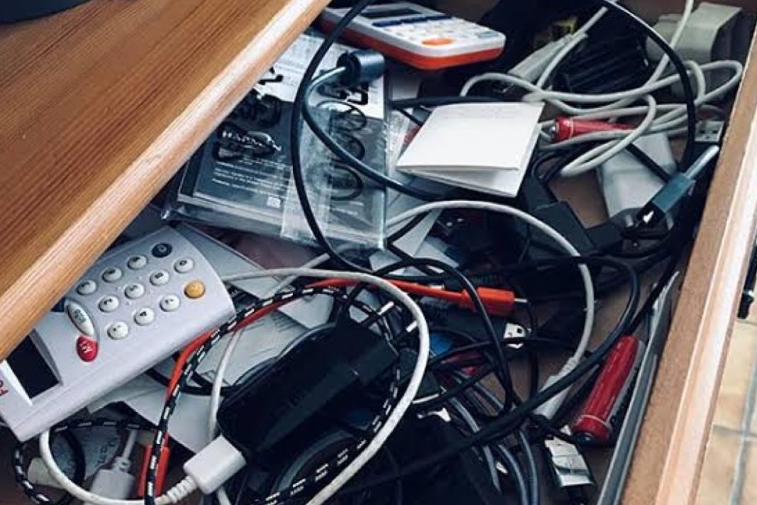 Old mobile phones, broken earbuds and obsolete electronics piled together representing the UK's growing ewaste mountain